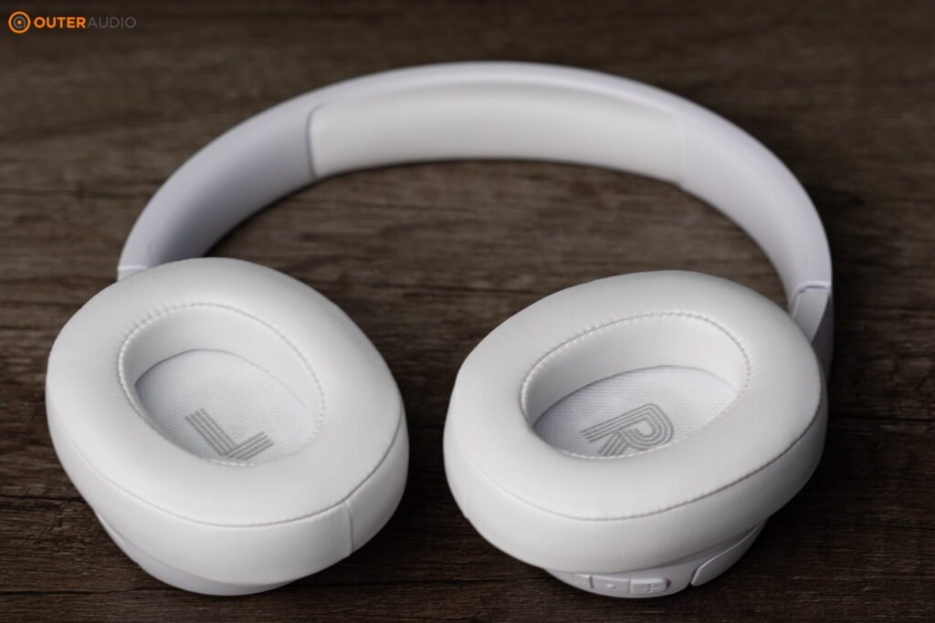 JBL Tune 770NC on a wooden backdrop, showing the inside of the earcups